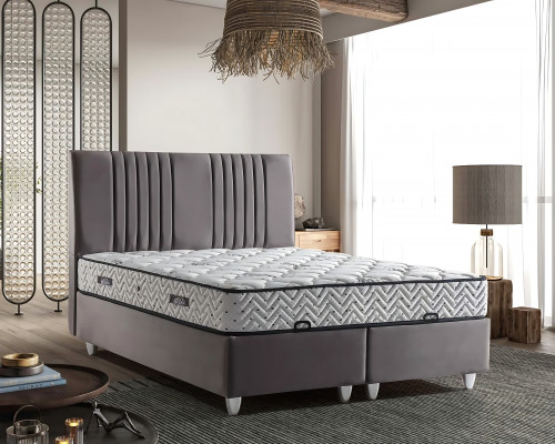 Postel z šedého materiálu s moderní matrací