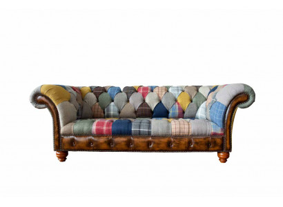 Chesterfield sofa z textilu a kůže na nohách z přírodního dřeva.