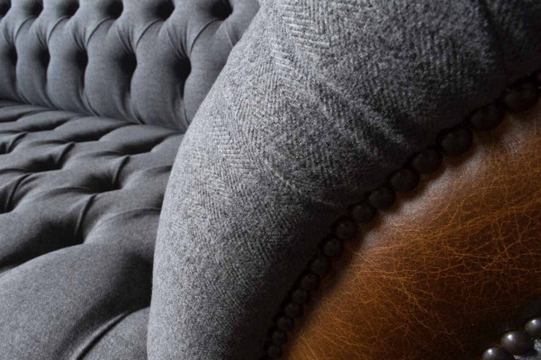Pohovka Chesterfield, luxusní látková pohovka, čalouněná sedačka, šedá textilní tkanina.