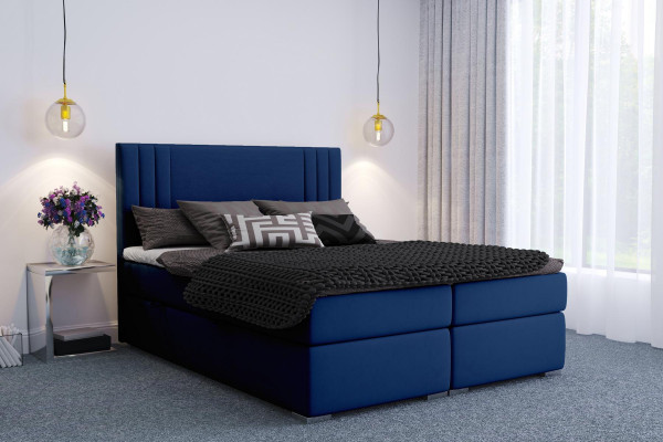Moderní postele typu boxspring v hotelu, dvojlůžkové luxusní postele s polstrovaným rámem a funkcí šuplíků.