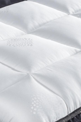 Černá postel s matrací a dvěma nočními stolky v sadě nábytku do ložnice.