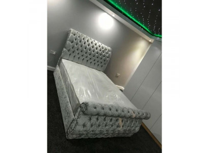 Sametová postel v designu Chesterfield s rámom postele v klasickém designu a novými polštáři.