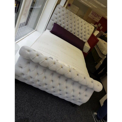 Sametová postel v designu Chesterfield s rámom postele v klasickém designu a novými polštáři.