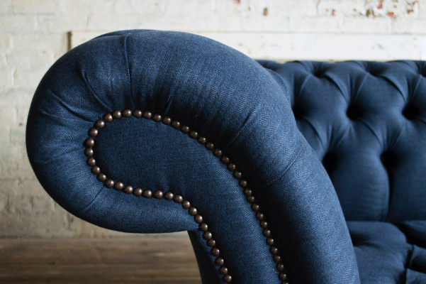 Modrá textilní pohovka Chesterfield s čtyřmi sedadly od designéra.
