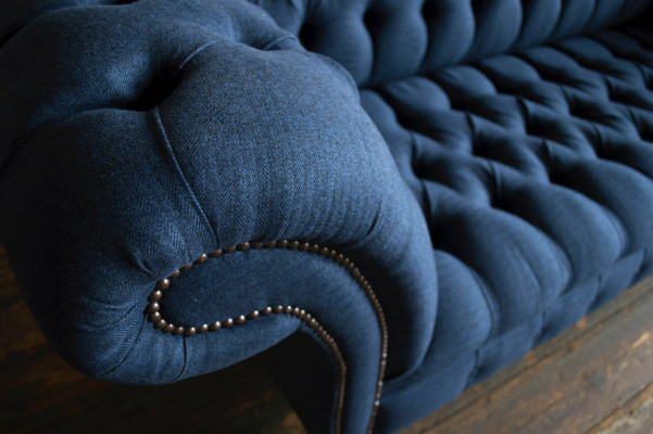 Modrá textilní pohovka Chesterfield s čtyřmi sedadly od designéra.