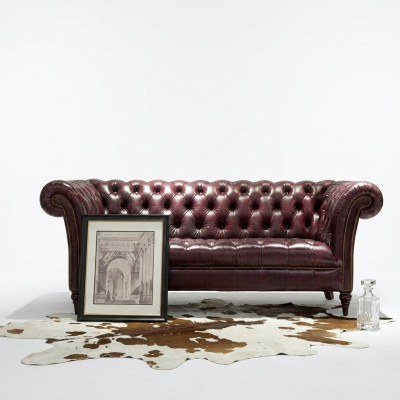 Chesterfield pohovka pro tři osoby, kožená pohovka hnědé barvy.