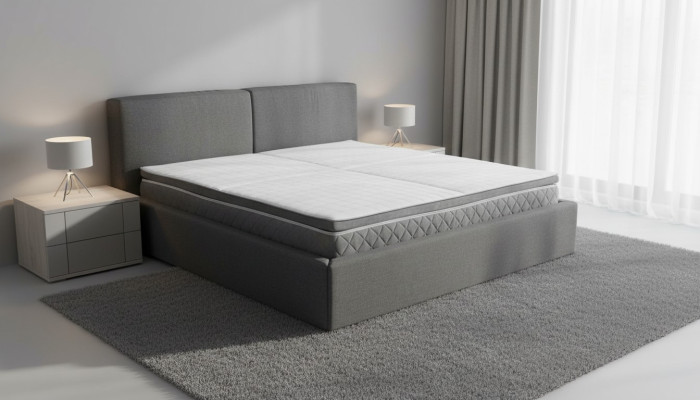 Šedá manželská postel s polstrováním, úložnými boxy, elegantní látkový design.